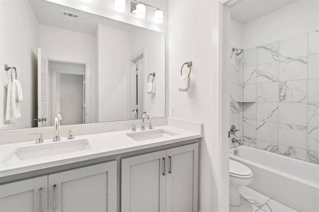 648 Courtyard Lane, Irving, TX 75039 2nd floor bathroom with dual sinks and separate shower area