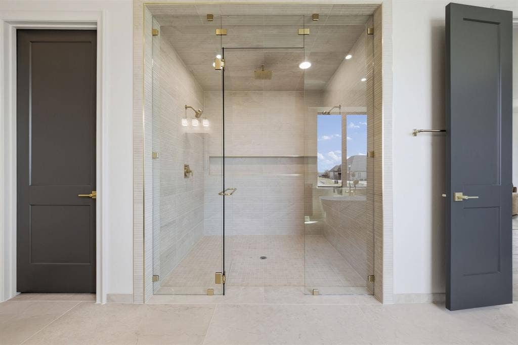 3333 Bridgegate Avenue, Northlake, TX 76247 Walk-in glass shower enclosure with brass hardware, tiled walls, and built-in shelving
