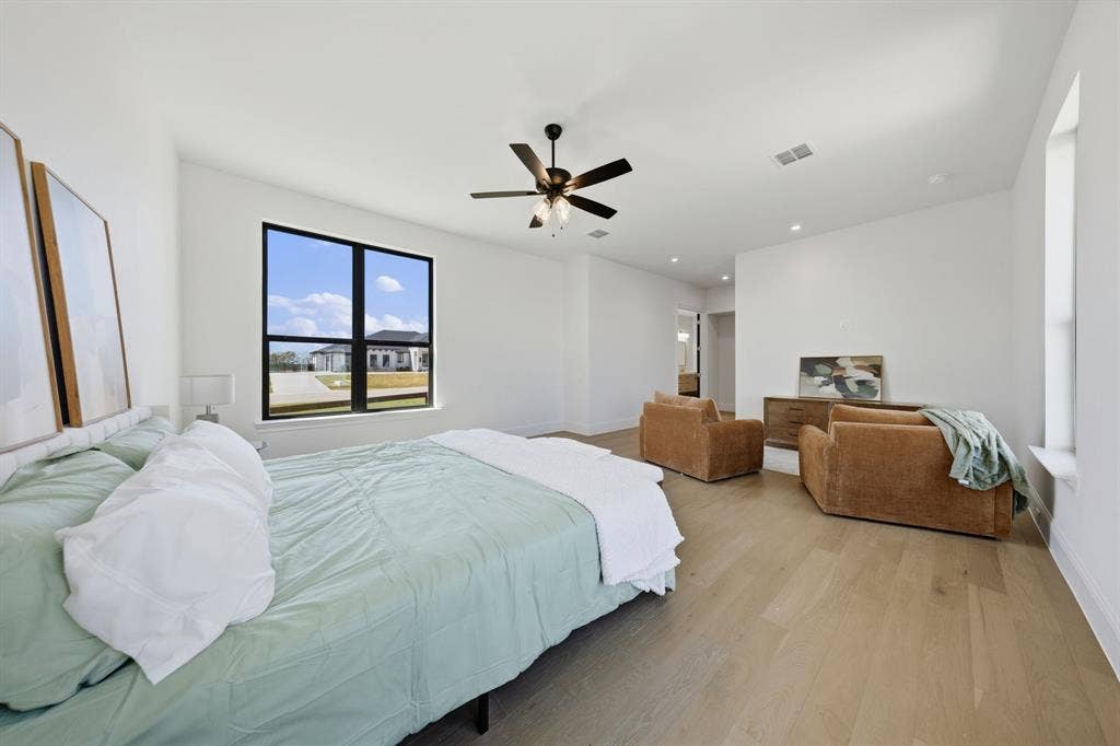 3333 Bridgegate Avenue, Northlake, TX 76247 Light wood-finish flooring, a contemporary ceiling fan, and recessed lighting illuminate the spacious room