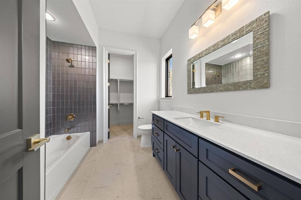 3333 Bridgegate Avenue, Northlake, TX 76247 Dual basin vanity with quartz countertops, dark cabinetry, and gold-finish fixtures