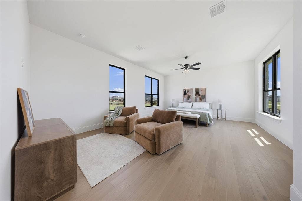 3333 Bridgegate Avenue, Northlake, TX 76247 Spacious room with light wood-finish flooring, multiple large windows with dark frames, and a ceiling fan with integrated lighting