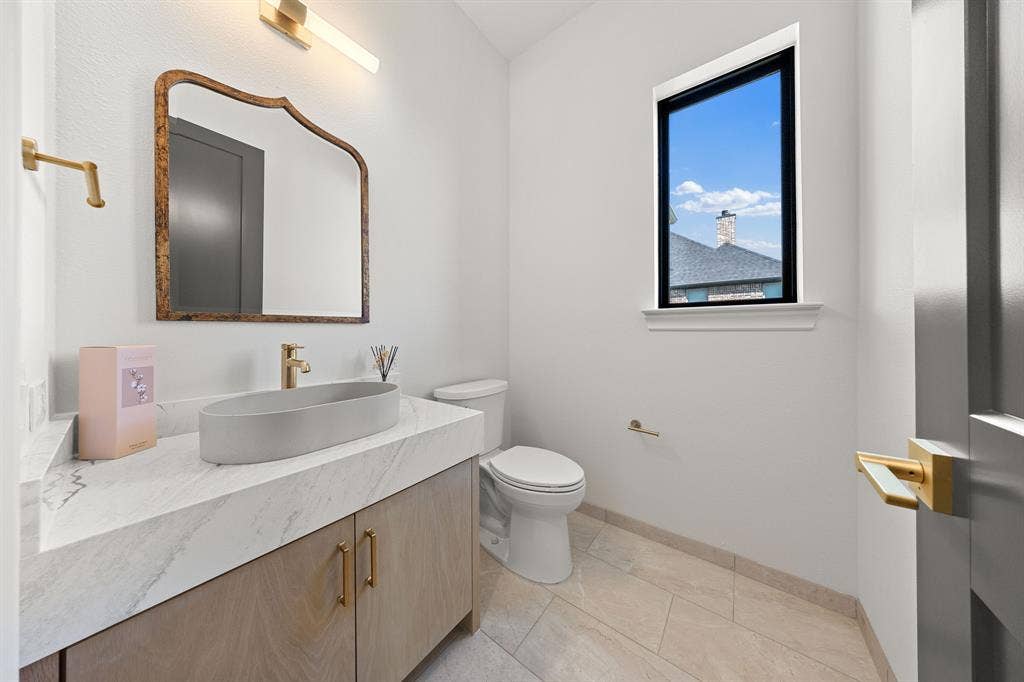 3333 Bridgegate Avenue, Northlake, TX 76247 Modern vanity with a vessel sink, stone countertop, and wood-finish cabinetry