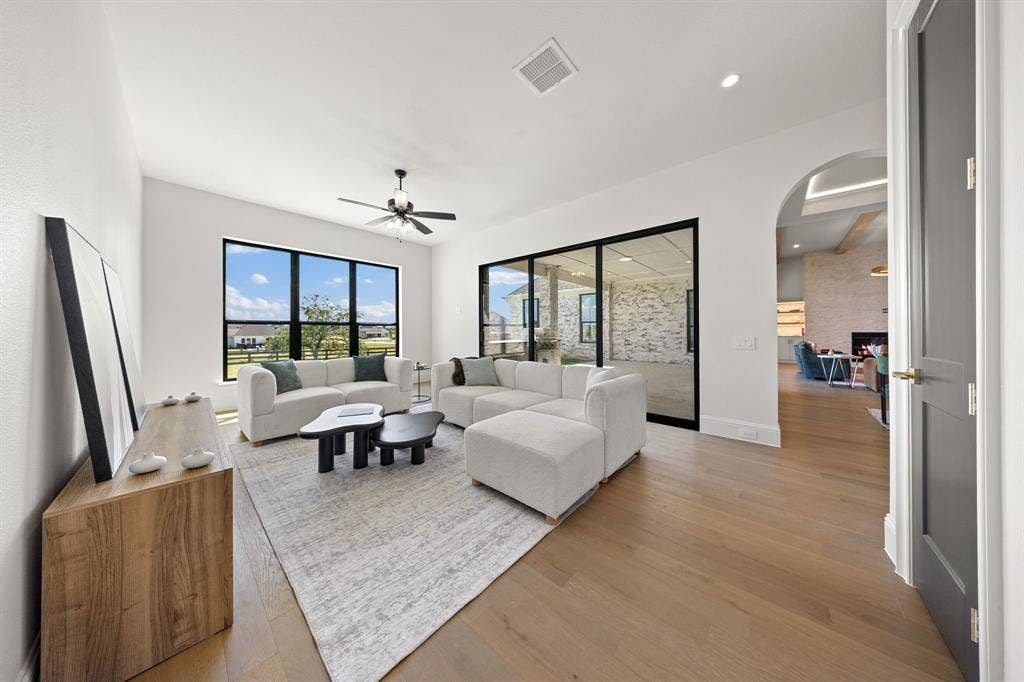 3333 Bridgegate Avenue, Northlake, TX 76247 Light wood-finish flooring, a ceiling fan, and recessed lighting enhance the open living area