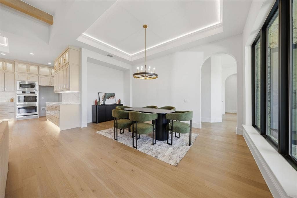 3333 Bridgegate Avenue, Northlake, TX 76247 Spacious open concept living area featuring light wood-finish flooring, a coffered ceiling with recessed lighting, and large black-framed windows