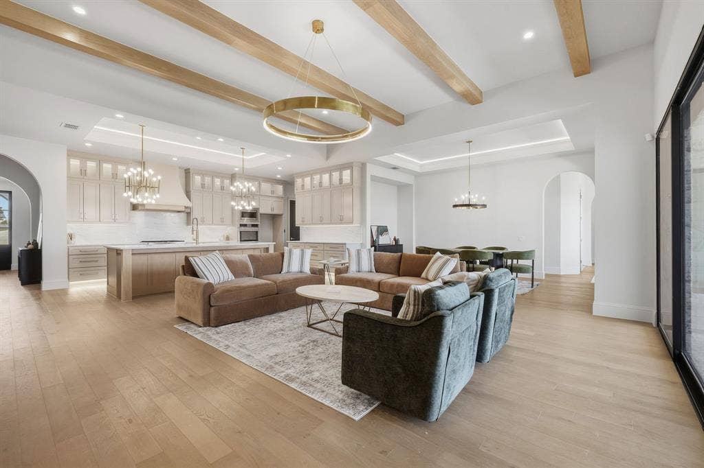 3333 Bridgegate Avenue, Northlake, TX 76247 Open-concept living space featuring wood-finish flooring, exposed ceiling beams, recessed lighting, and expansive glass sliding doors