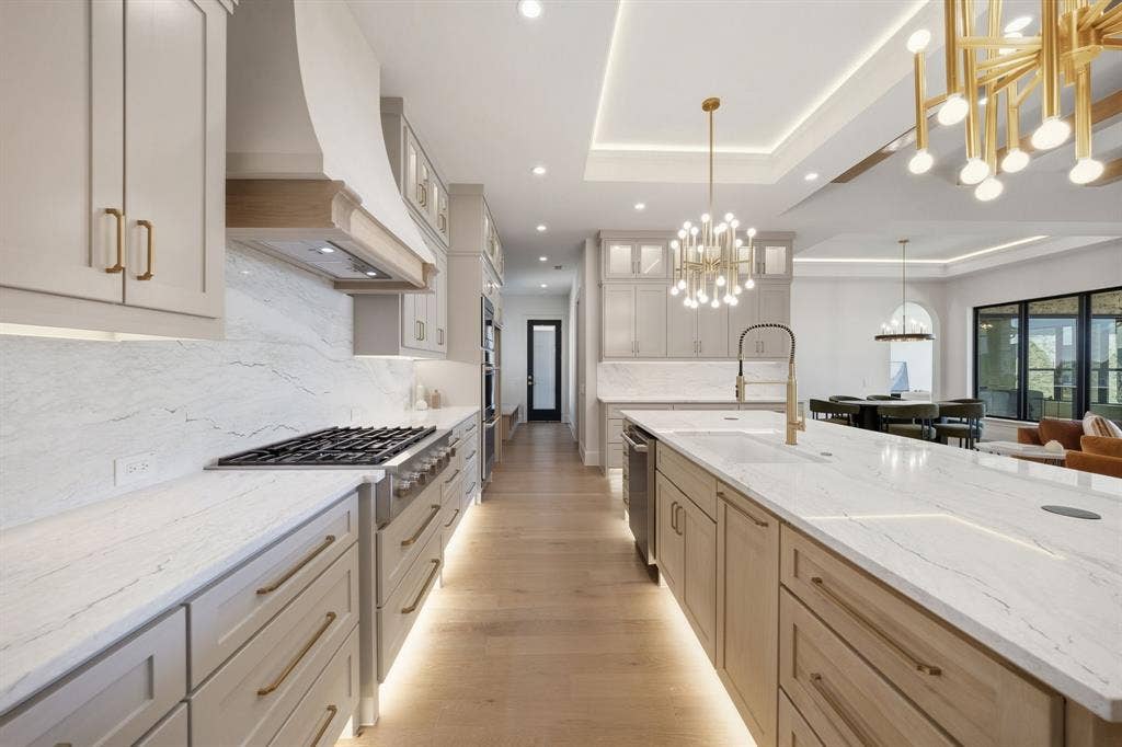 3333 Bridgegate Avenue, Northlake, TX 76247 Expansive kitchen featuring a gas range, white stone countertops, wood-finish flooring, recessed lighting, and a large central island with a sink