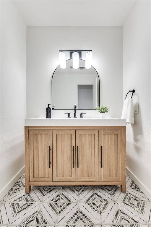 2601 Red Oak Lane, Plano, TX 75075 Your guests will love this stylish powder bath featuring modern black fixtures and patterned tile flooring.