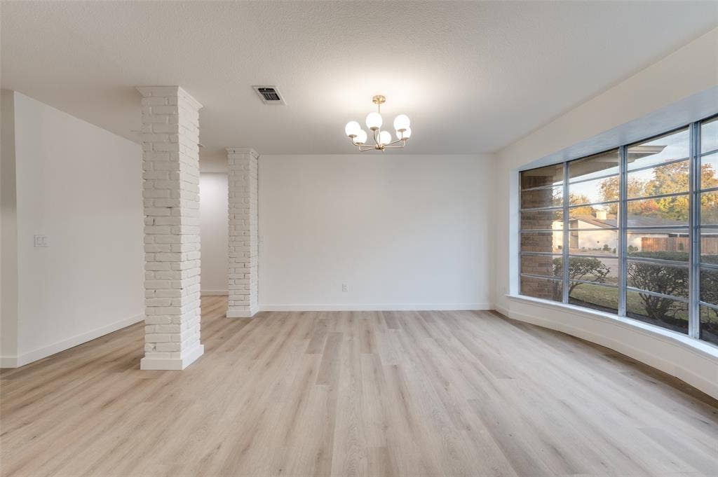 2601 Red Oak Lane, Plano, TX 75075 Architectural brick columns add character while maintaining an open-concept connection between dining and living areas, with easy access to the kitchen.