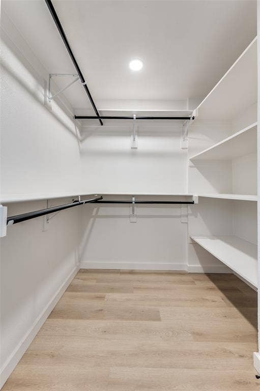 2601 Red Oak Lane, Plano, TX 75075 Spacious walk-in closet featuring custom shelving, double hanging rods, and upgraded lighting for excellent storage and organization.
