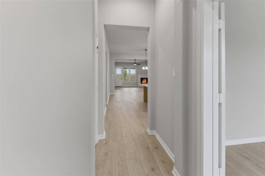 15056 Green Bluff Drive, Aledo, TX 76008 Hallway featuring light wood-finish flooring, white baseboards, and neutral wall tones