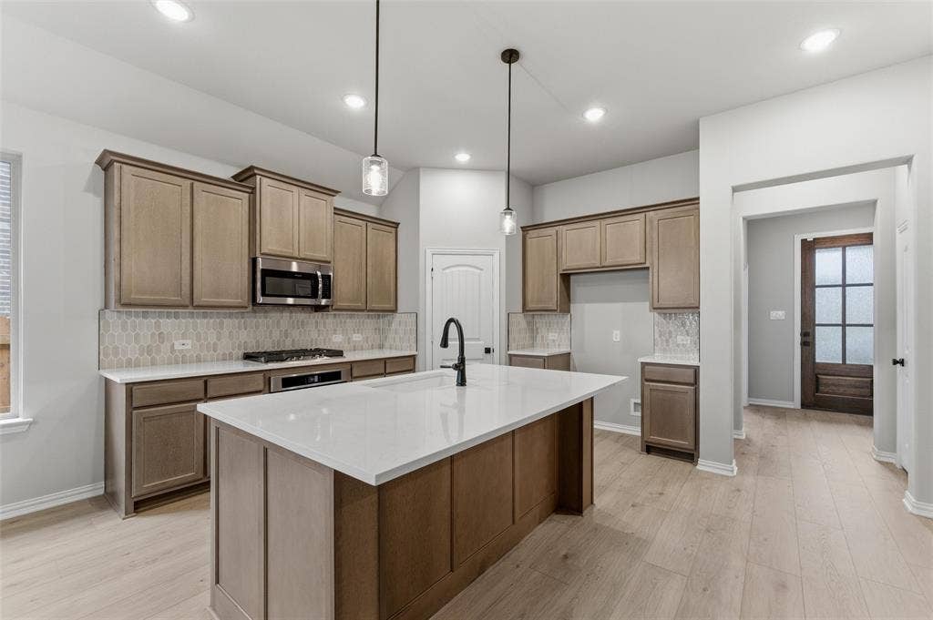 15056 Green Bluff Drive, Aledo, TX 76008 Kitchen featuring a large central island with a white countertop and a matte black gooseneck faucet