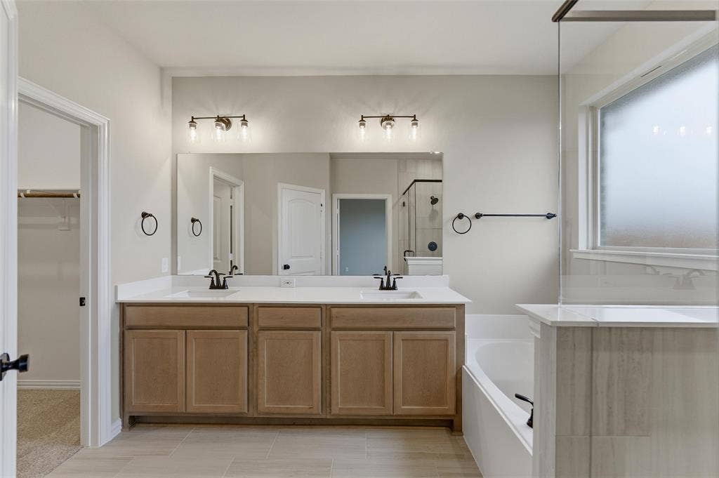 15056 Green Bluff Drive, Aledo, TX 76008 Bathroom featuring a double vanity with light wood-finish cabinetry, white countertops, and black hardware