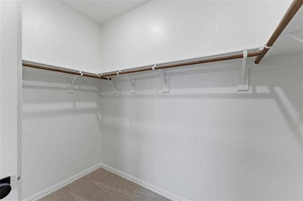 15056 Green Bluff Drive, Aledo, TX 76008 Walk-in closet featuring light-colored carpeting, white baseboards, and a wrap-around hanging rod system