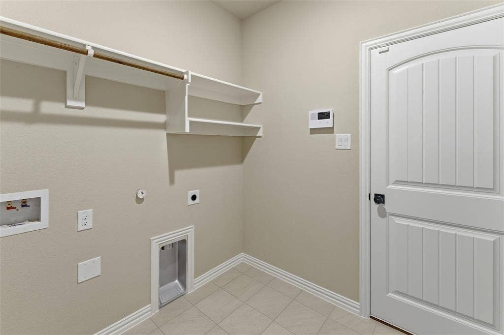 15056 Green Bluff Drive, Aledo, TX 76008 Utility area featuring built-in shelving, a clothing rod, washer/dryer hookups, and neutral wall tones