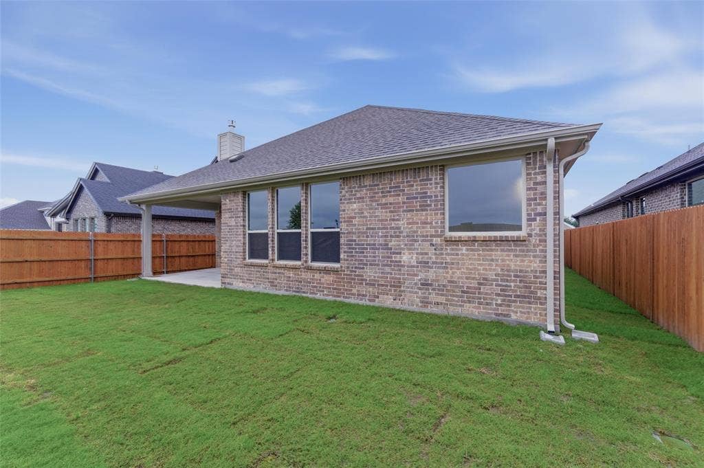 15056 Green Bluff Drive, Aledo, TX 76008 Expansive rear yard featuring green lawn, a covered patio, and a privacy fence