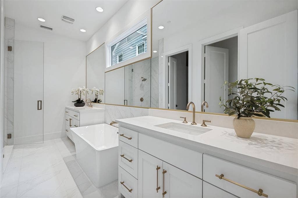 4635 Lorraine Avenue, Highland Park, TX 75209 The relaxing primary bathroom features light tile finishes, a generous sized walk-in shower, and a separate soaking tub.