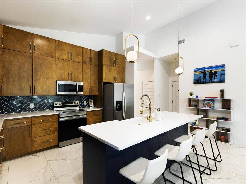 6221 Inca Drive, Mabank, TX 75156 Kitchen featuring stainless steel appliances, lofted ceiling, a center island with sink, a breakfast bar, and backsplash