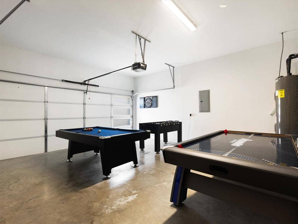 6221 Inca Drive, Mabank, TX 75156 Playroom with billiards, a garage, finished concrete flooring, water heater, and electric panel