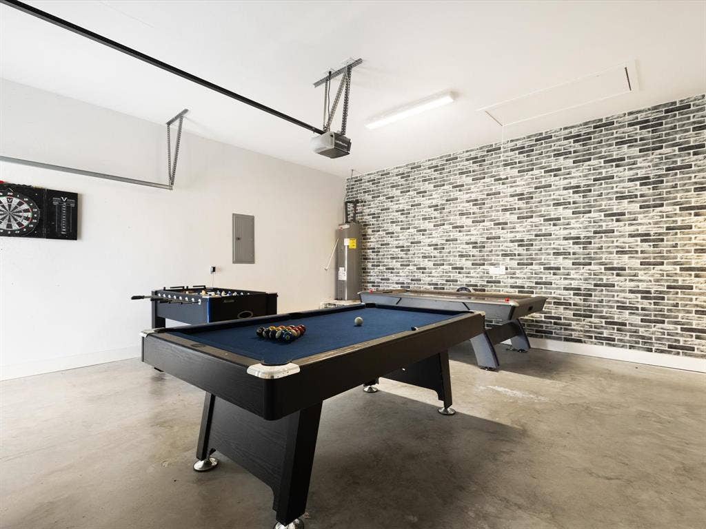 6221 Inca Drive, Mabank, TX 75156 Recreation room with a garage, billiards table, finished concrete floors, brick wall, and water heater