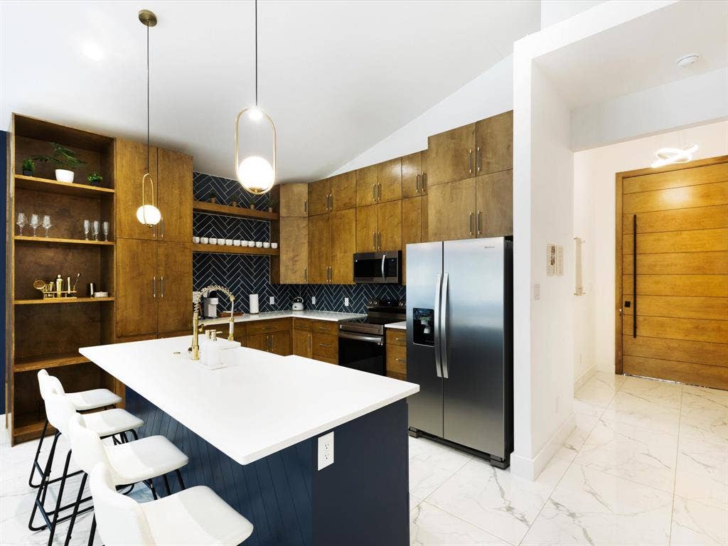6221 Inca Drive, Mabank, TX 75156 Kitchen featuring stainless steel appliances, pendant lighting, vaulted ceiling, a center island with sink, and a kitchen breakfast bar