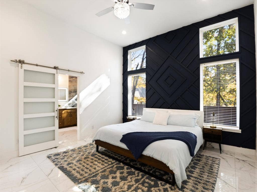 6221 Inca Drive, Mabank, TX 75156 Bedroom featuring a barn door, connected bathroom, light marble finish floors, ceiling fan, and recessed lighting