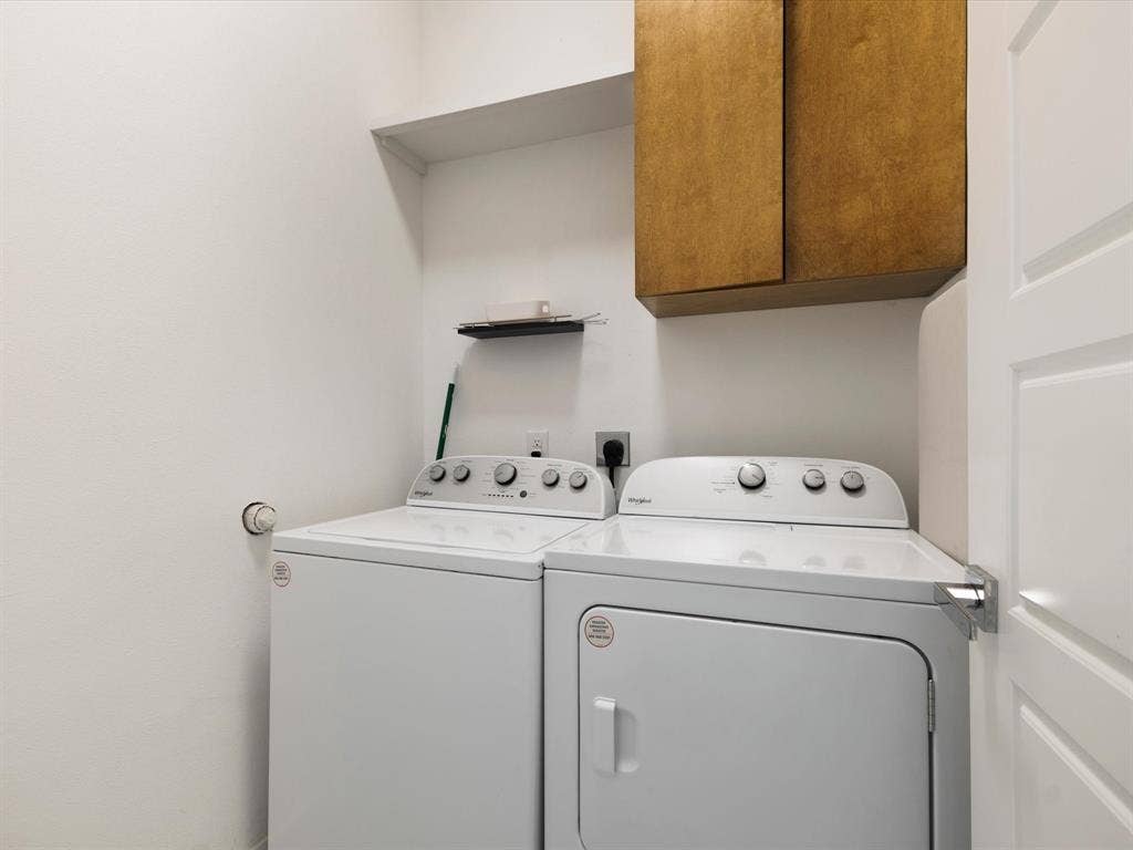6221 Inca Drive, Mabank, TX 75156 Laundry room with cabinet space and washing machine and clothes dryer