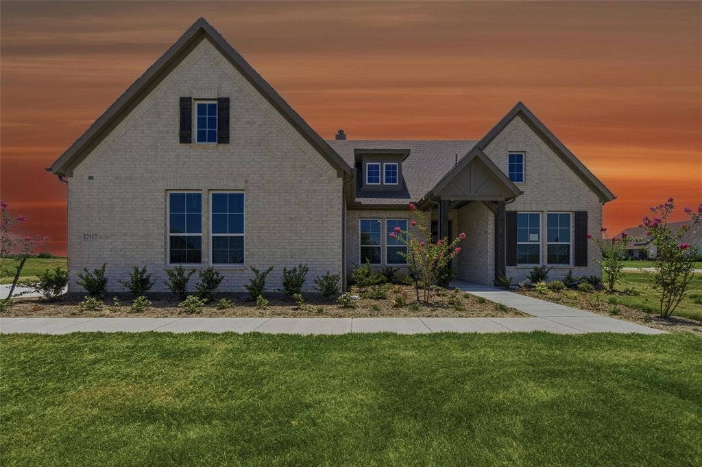 12117 Clastic Court, Krum, TX 76249 Traditional-style residence featuring a light brick exterior and dark shutters