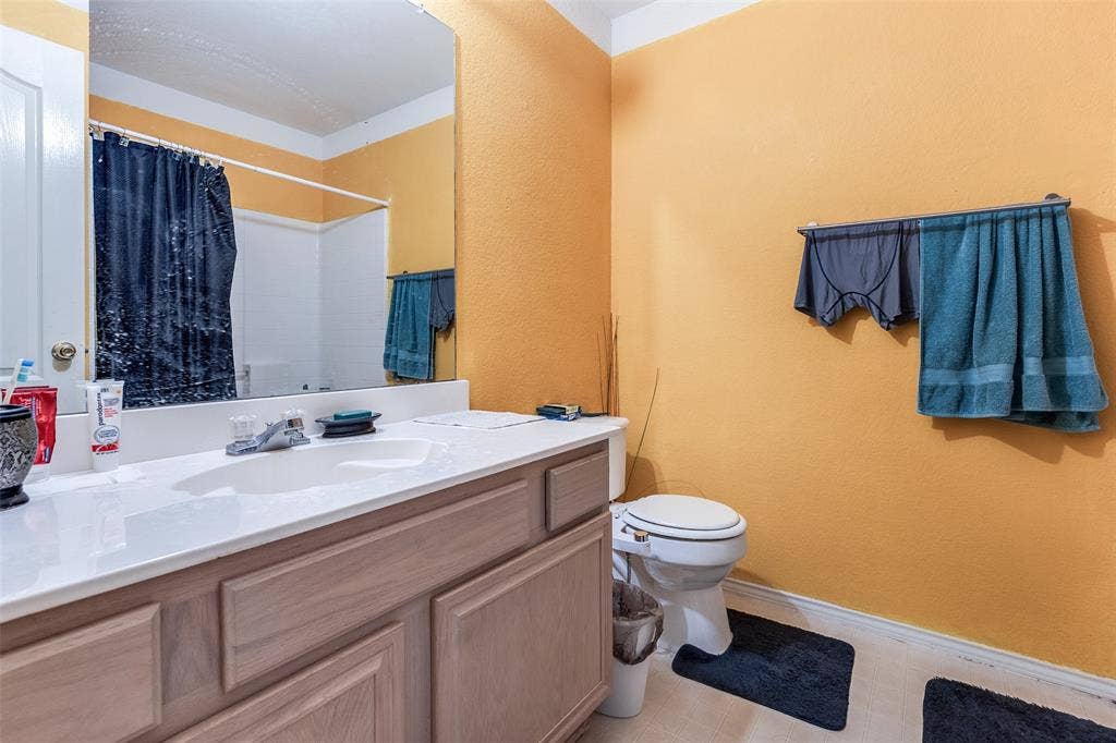 Bedroom featuring vaulted ceiling, carpet flooring, and ceiling fan