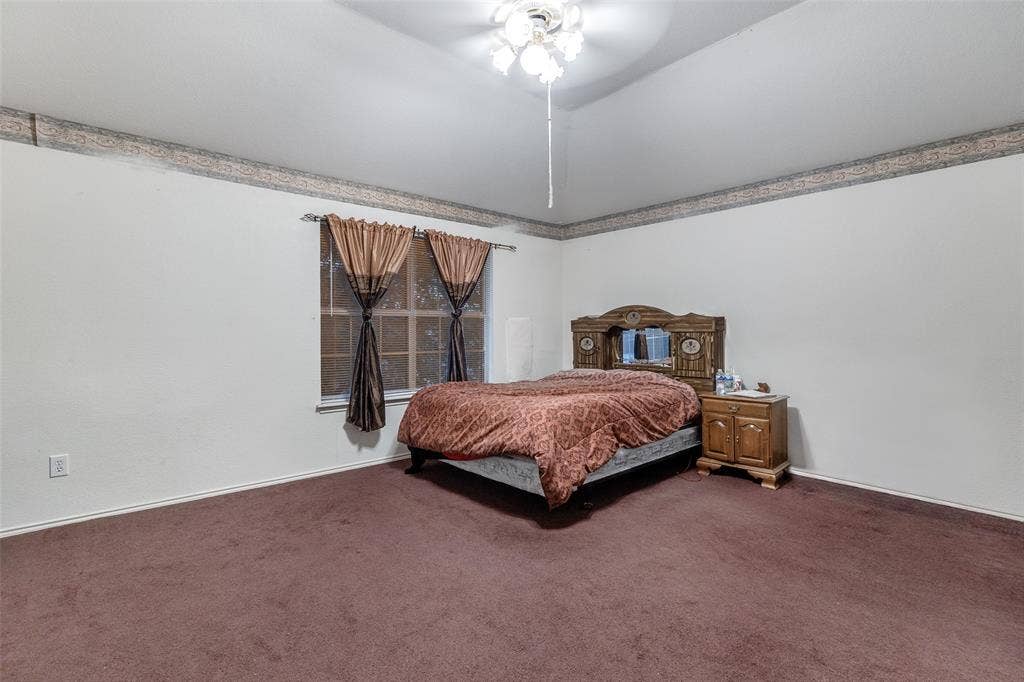 Bedroom featuring vaulted ceiling, carpet flooring, and ceiling fan