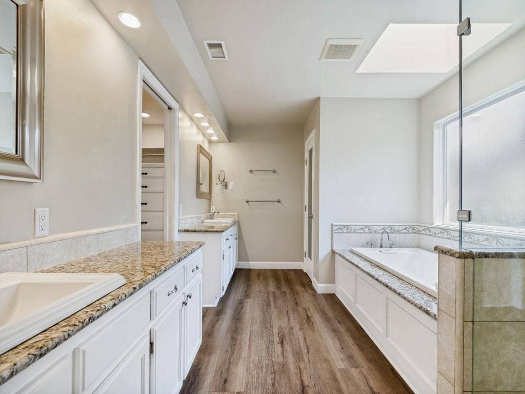 108 Wellesley Drive, Irving, TX 75062 Primary Bathroom with vanity, a shower stall, a bath, and dark wood-type flooring