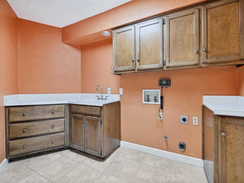 108 Wellesley Drive, Irving, TX 75062 Laundry area - Full Size washer dryer area with skylight, cabinet space, and light tile patterned floors