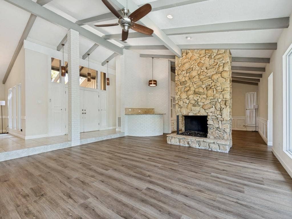 108 Wellesley Drive, Irving, TX 75062 Living room with lofted ceiling, a ceiling fan, light wood-style flooring, and a stone fireplace