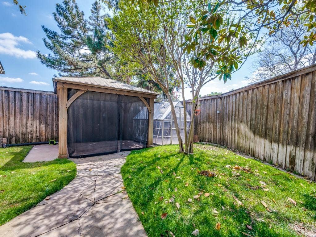108 Wellesley Drive, Irving, TX 75062 Fenced backyard featuring a gazebo and green house