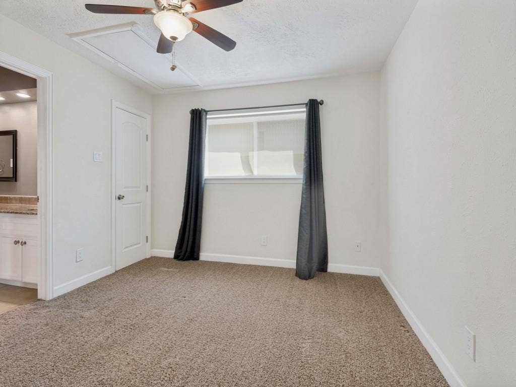 108 Wellesley Drive, Irving, TX 75062 Secondary Bedroom with light carpet, ensuite bath, a ceiling fan, and a textured ceiling