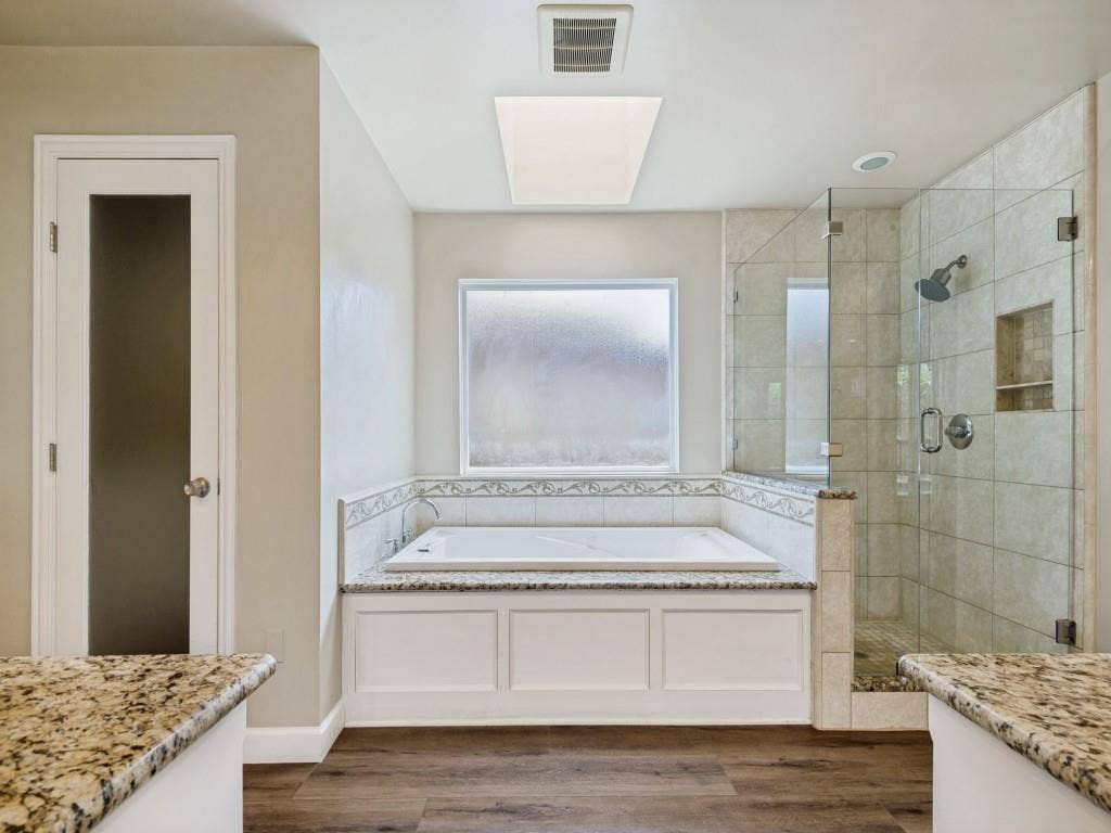 108 Wellesley Drive, Irving, TX 75062 Primary Bathroom with vanity, a shower stall, a bath, and dark wood-type flooring