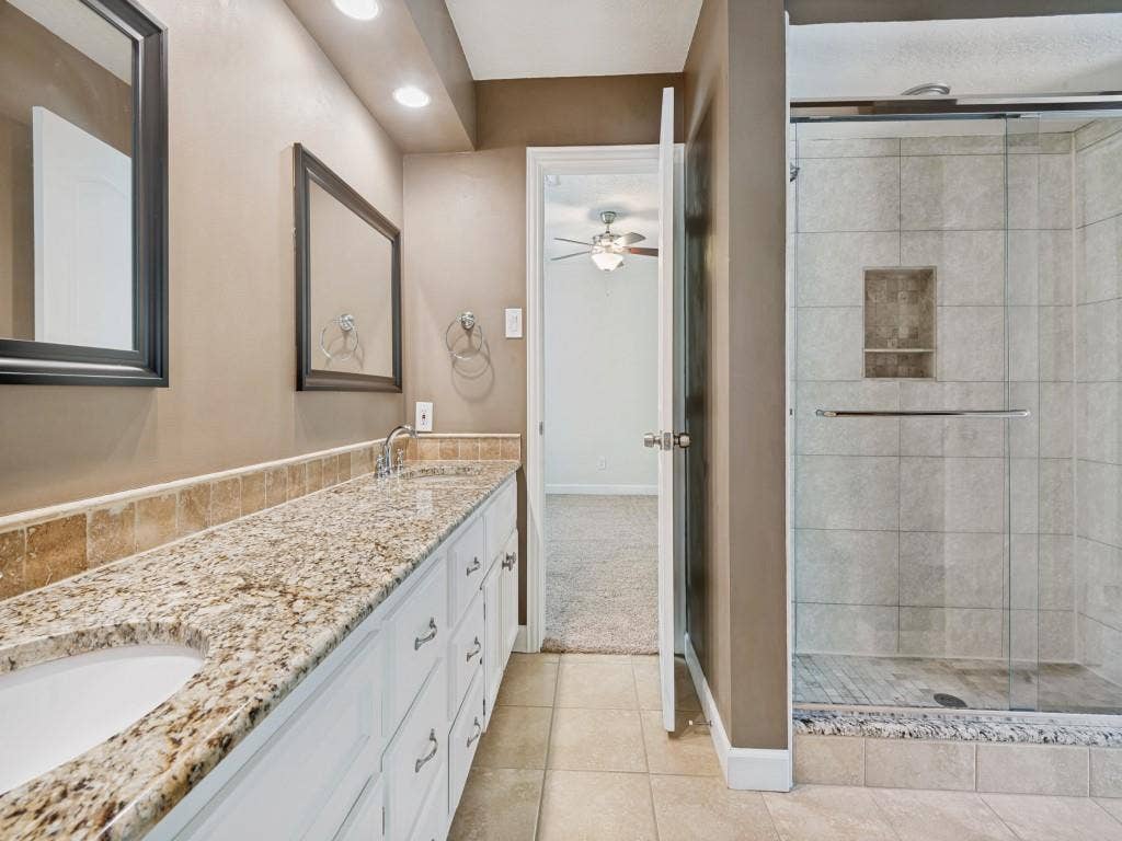 108 Wellesley Drive, Irving, TX 75062 Bathroom with double vanity, a stall shower, light tile patterned floors, recessed lighting, and a ceiling fan