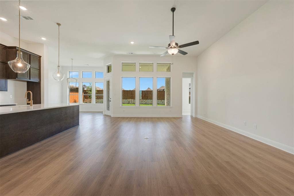Spacious open-concept interior featuring light wood-finish flooring and high vaulted ceilings