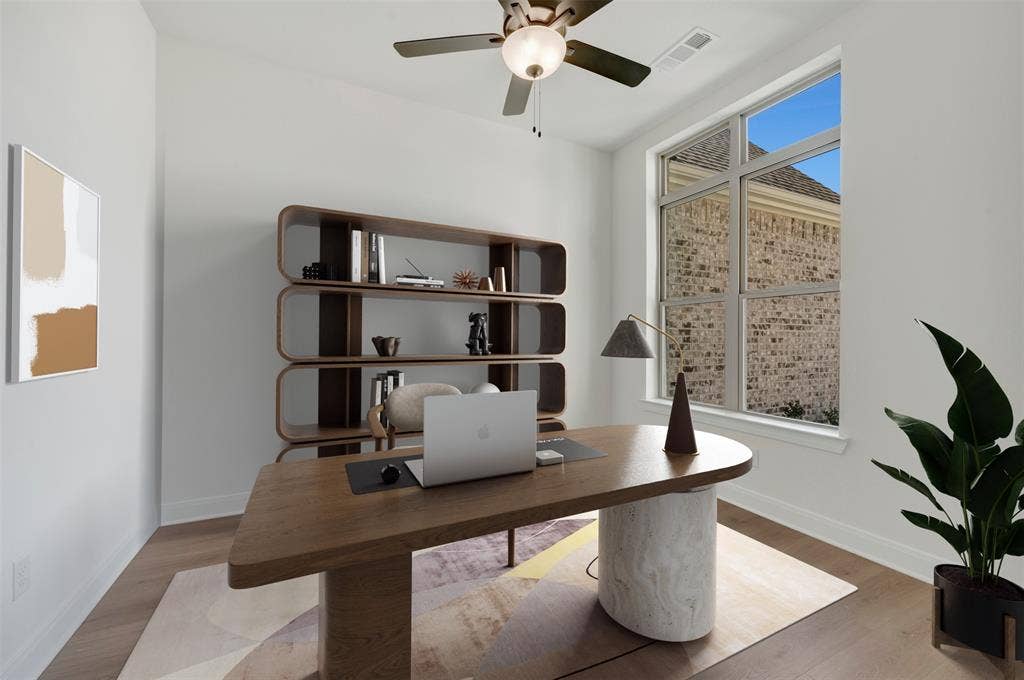 Spacious room featuring wood-finish flooring and a contemporary ceiling fan