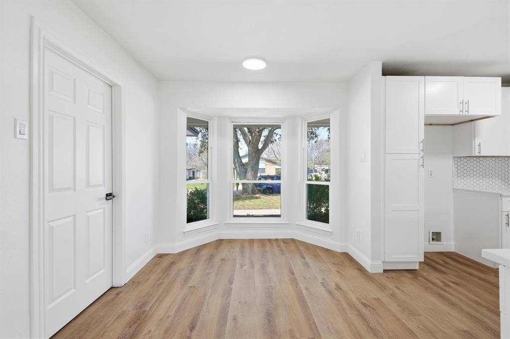 2211 Sierra Drive, Grapevine, TX 76051 Unfurnished dining area featuring light wood-style floors and baseboards