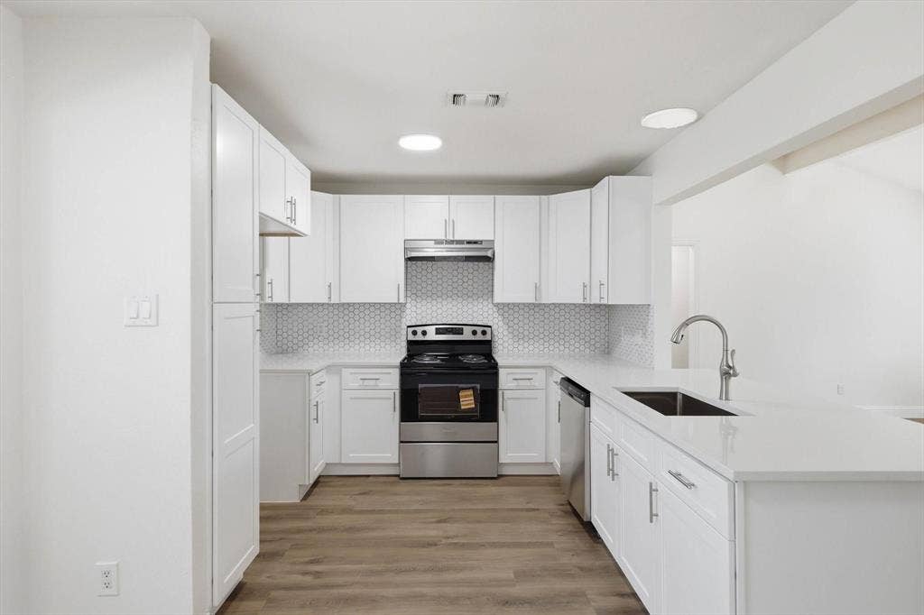 2211 Sierra Drive, Grapevine, TX 76051 Kitchen featuring stainless steel appliances, white cabinets, light wood-type flooring, and a peninsula
