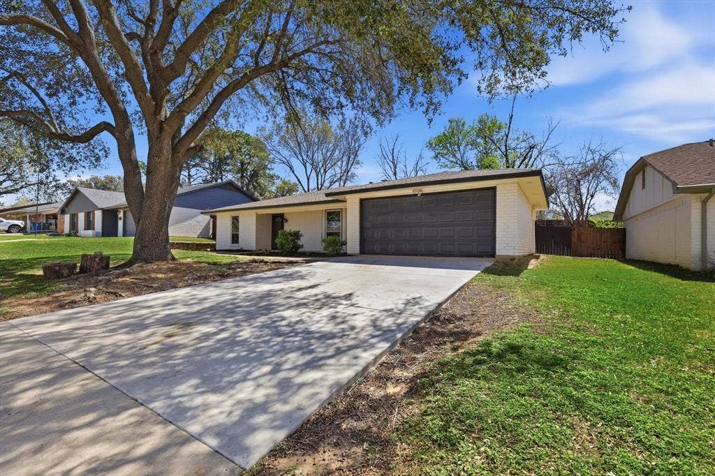 2211 Sierra Drive, Grapevine, TX 76051 View of front of house with concrete driveway, an attached garage, and brick siding