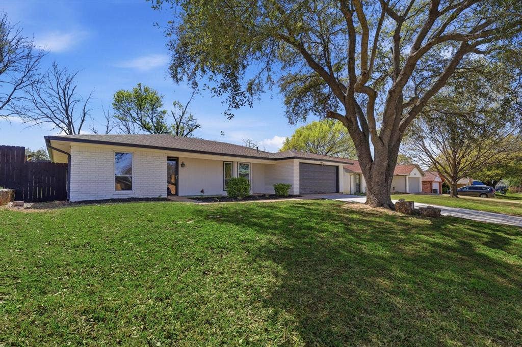 2211 Sierra Drive, Grapevine, TX 76051 Ranch-style house featuring an attached garage, brick siding, and driveway