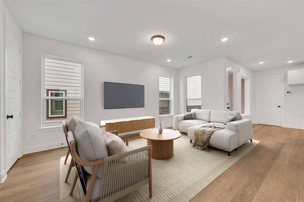 4721 Vizsla Lane, McKinney, TX 75071 Open-concept living space featuring wood-finish flooring, recessed lighting, and white trim throughout