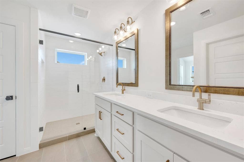 4721 Vizsla Lane, McKinney, TX 75071 Dual vanity with integrated sinks, white cabinetry, and brushed gold fixtures