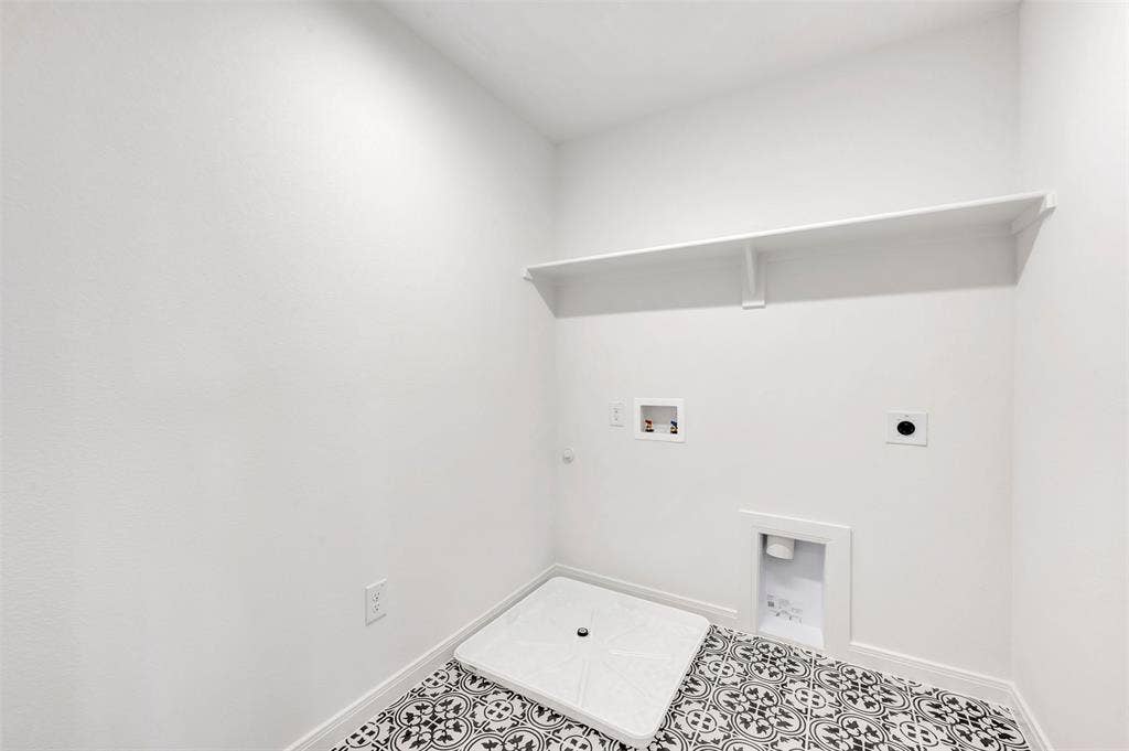 4721 Vizsla Lane, McKinney, TX 75071 Utility space featuring patterned black and white floor tiles, a built-in white shelf, and all-white walls