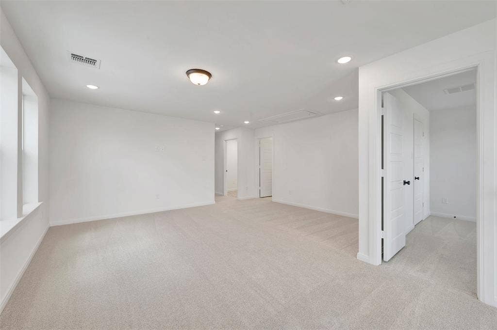 4721 Vizsla Lane, McKinney, TX 75071 Spacious room featuring light-toned carpeting, multiple recessed lights, and white paneled doors with dark hardware