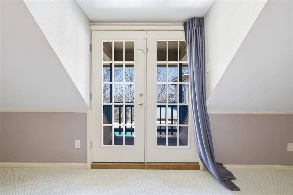 Exit to balcony with french doors and carpet floors