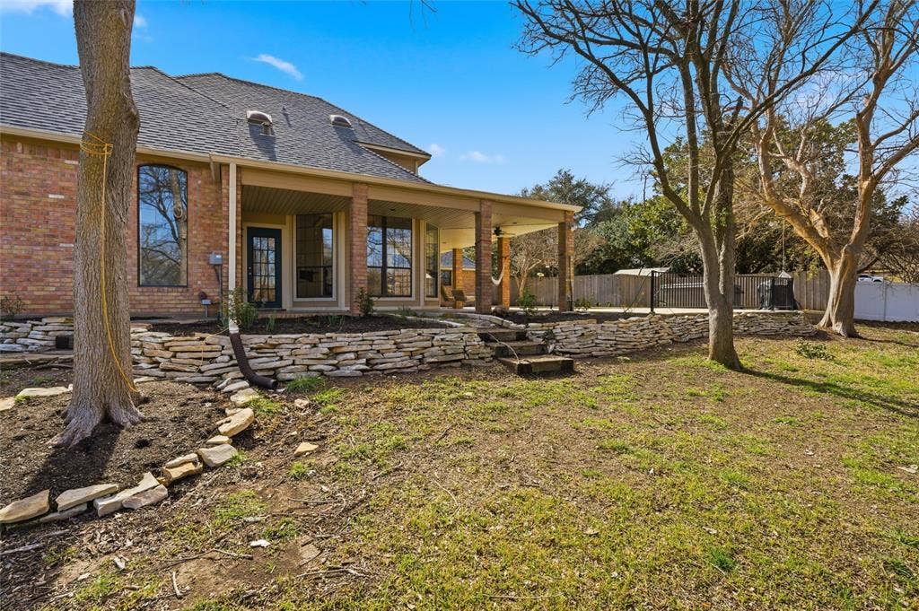Rear view of house with a patio, and brick siding.