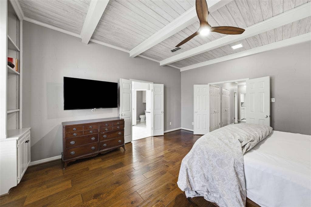 Bedroom featuring dark wood finished floors, a ceiling fan, and a wooden ceiling with exposed beams
