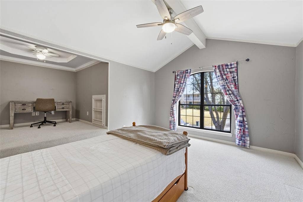 Bedroom featuring carpet floors, beamed ceiling, and a ceiling fan.